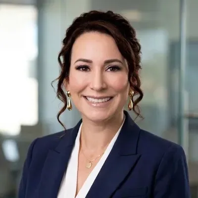 Dr. Adrianne Phillips, founder of PS Inc, smiling in a navy blazer against a softly blurred office background.